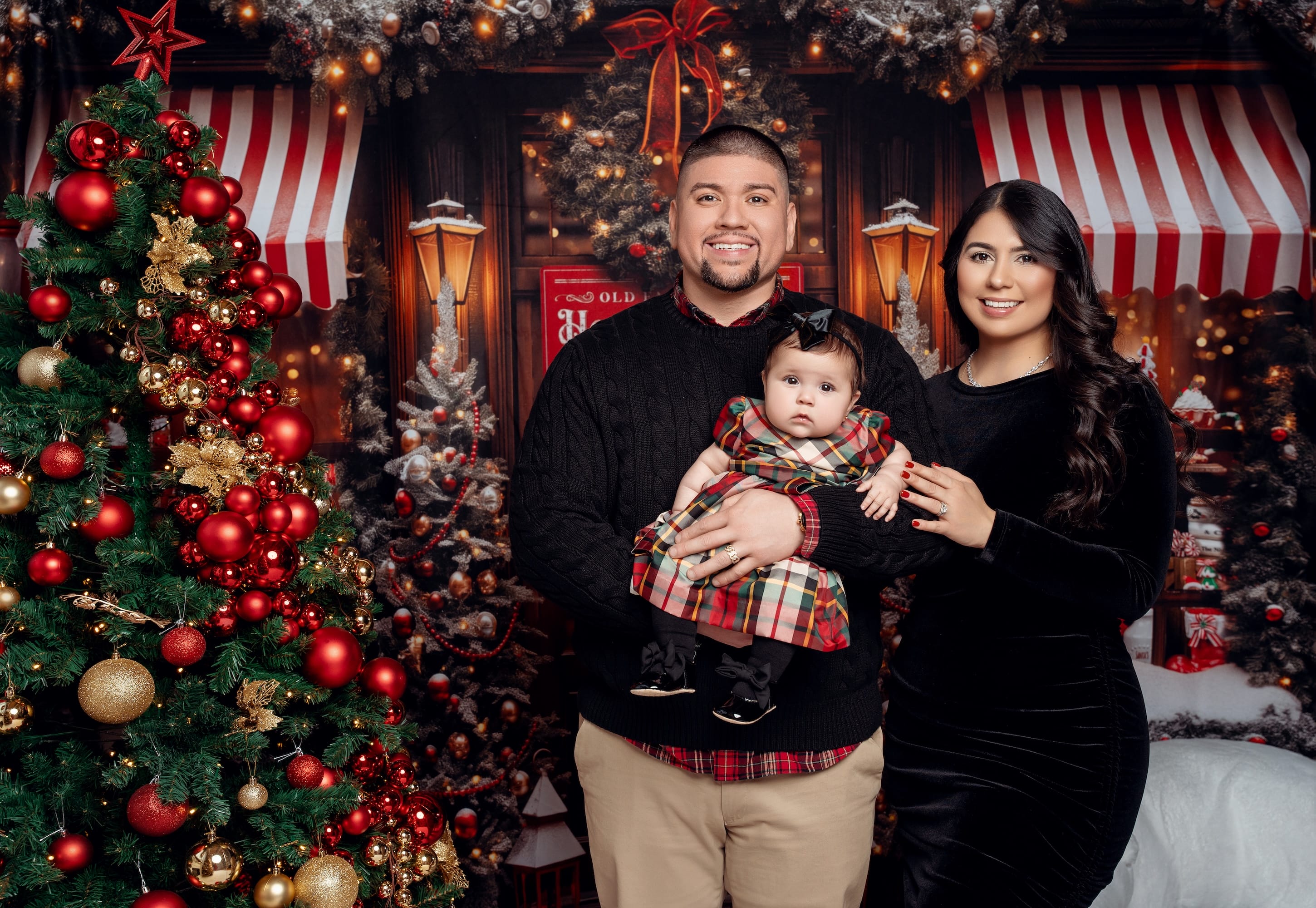 Family in black outfits sharing hot cocoa during a Christmas photo session
