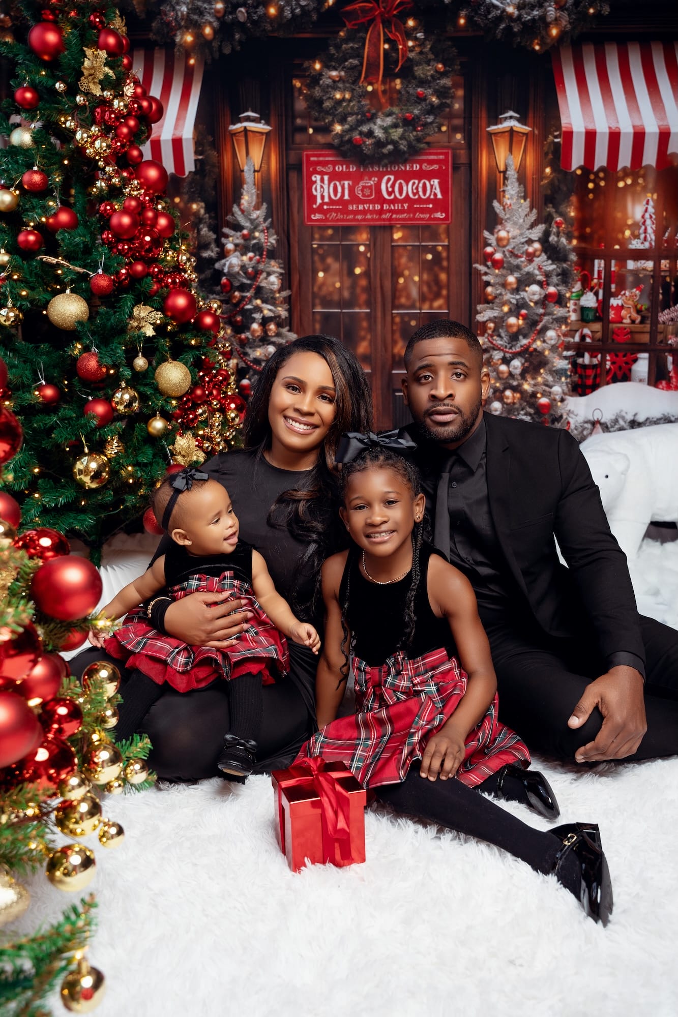 Family enjoying a cozy hot cocoa moment in a Christmas studio