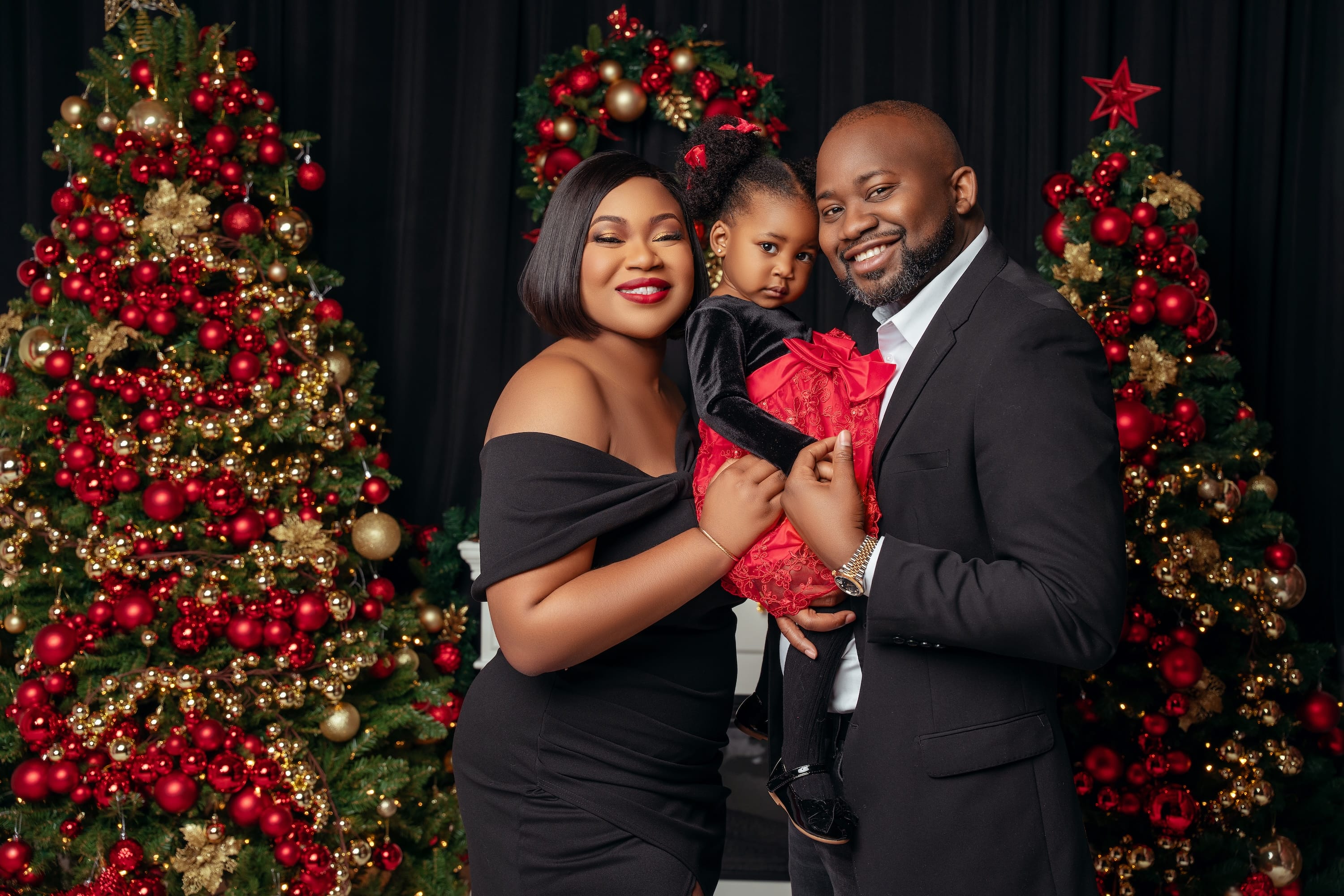 Elegant family Christmas portrait beside a decorated tree