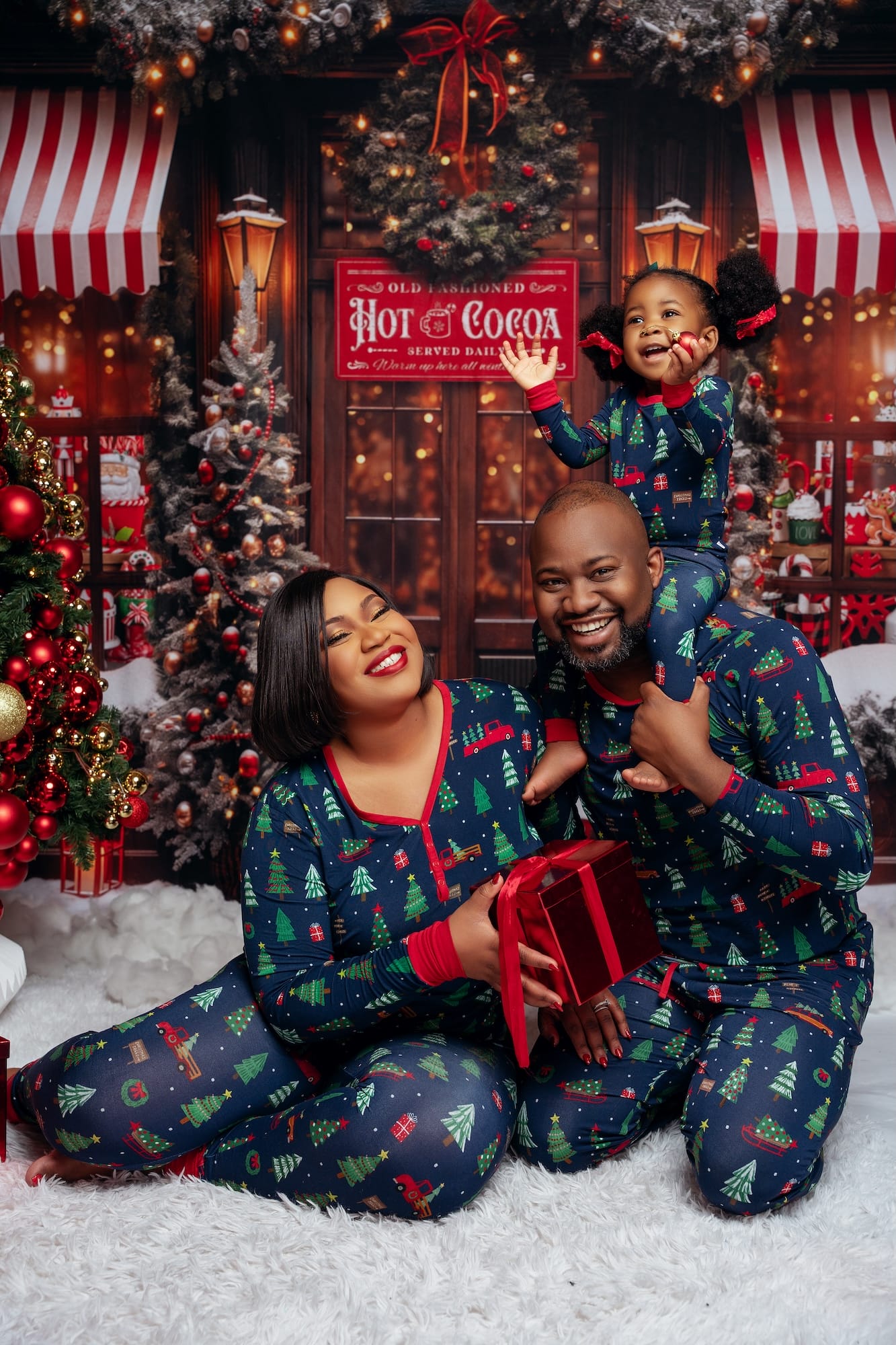 Family in matching pajamas laughing over hot cocoa at Christmas