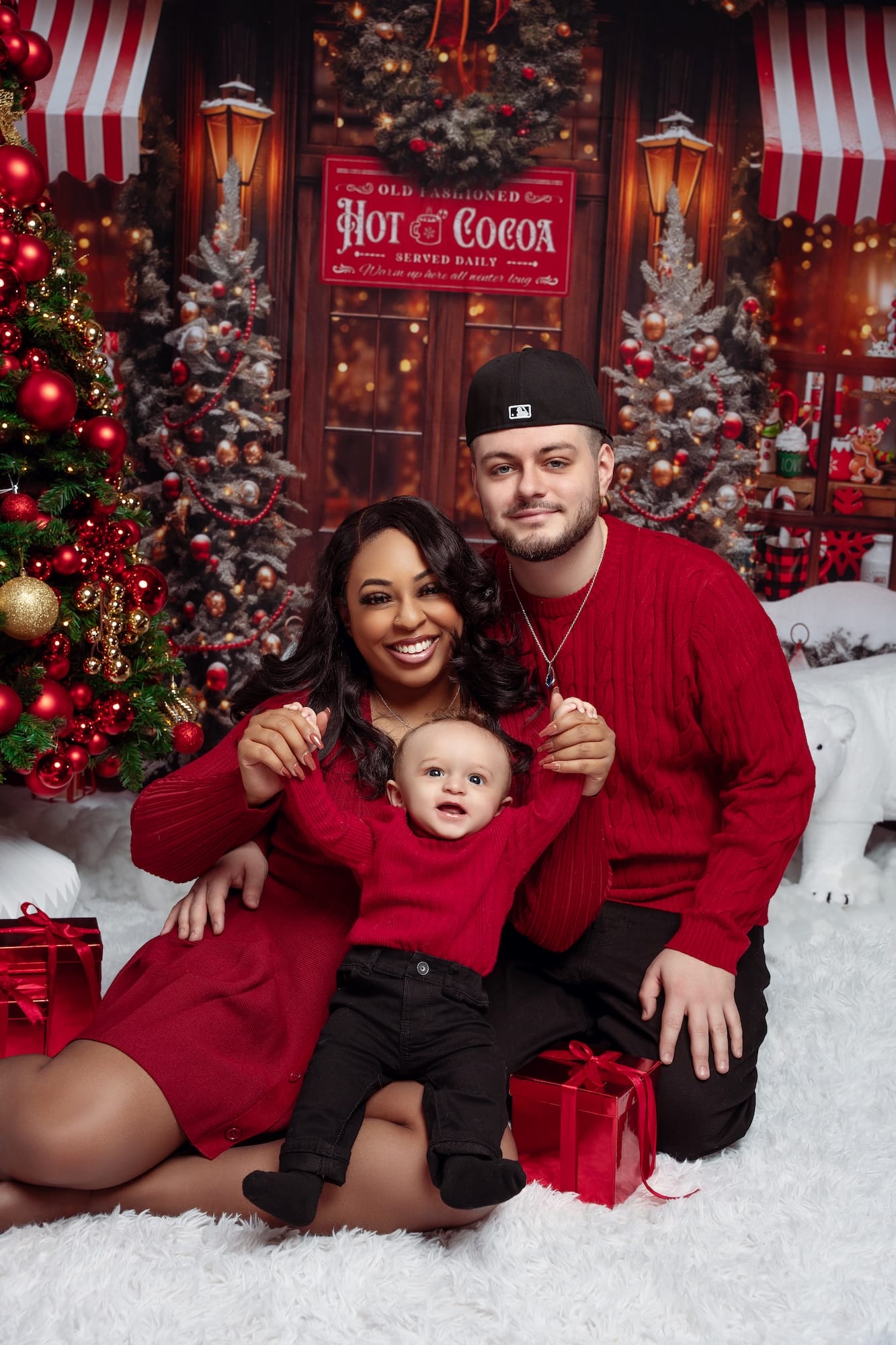 Family in red outfits enjoying hot cocoa in a Christmas studio