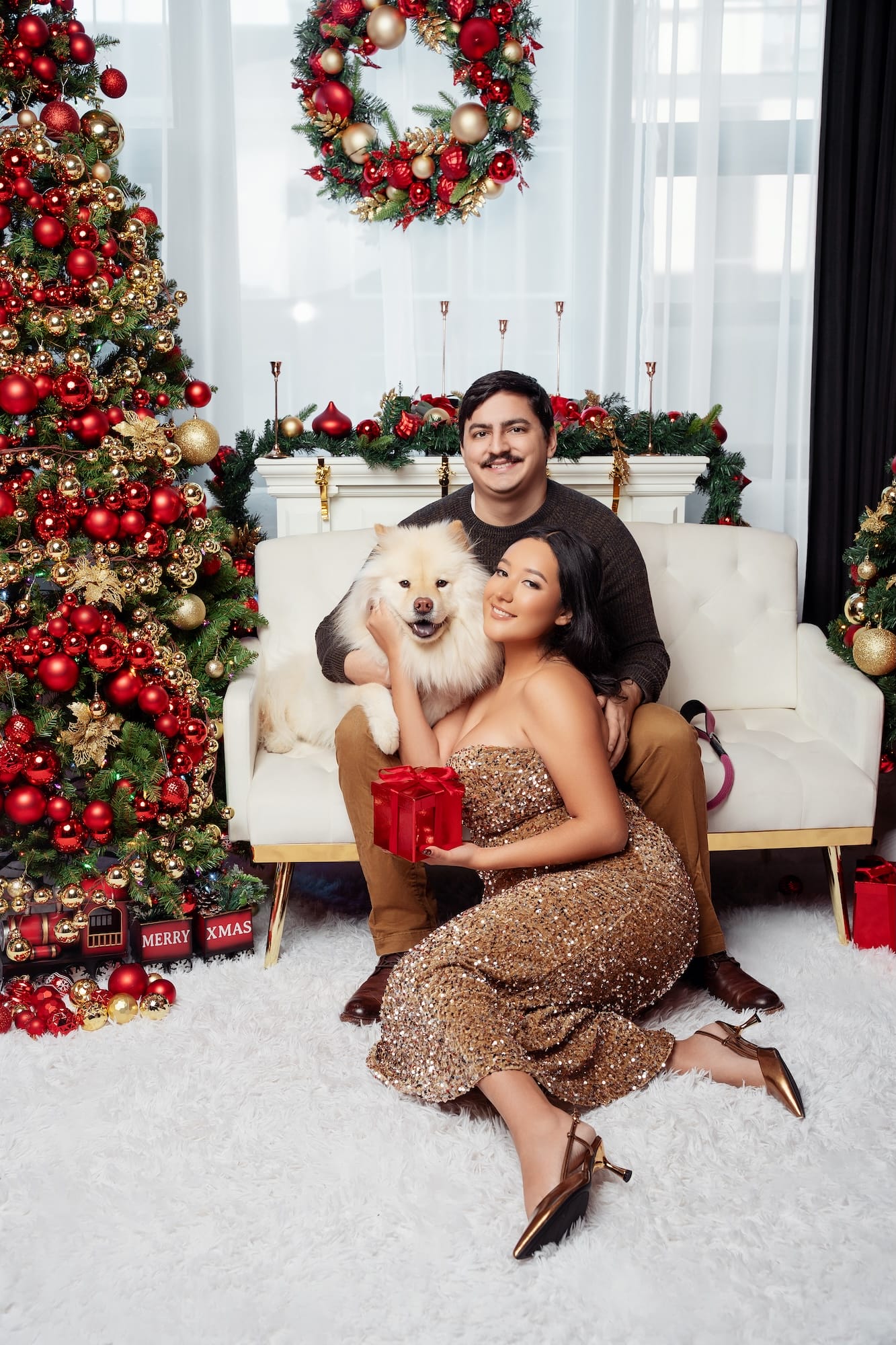 Woman cuddling her dog beside Christmas gifts in a festive holiday photo session