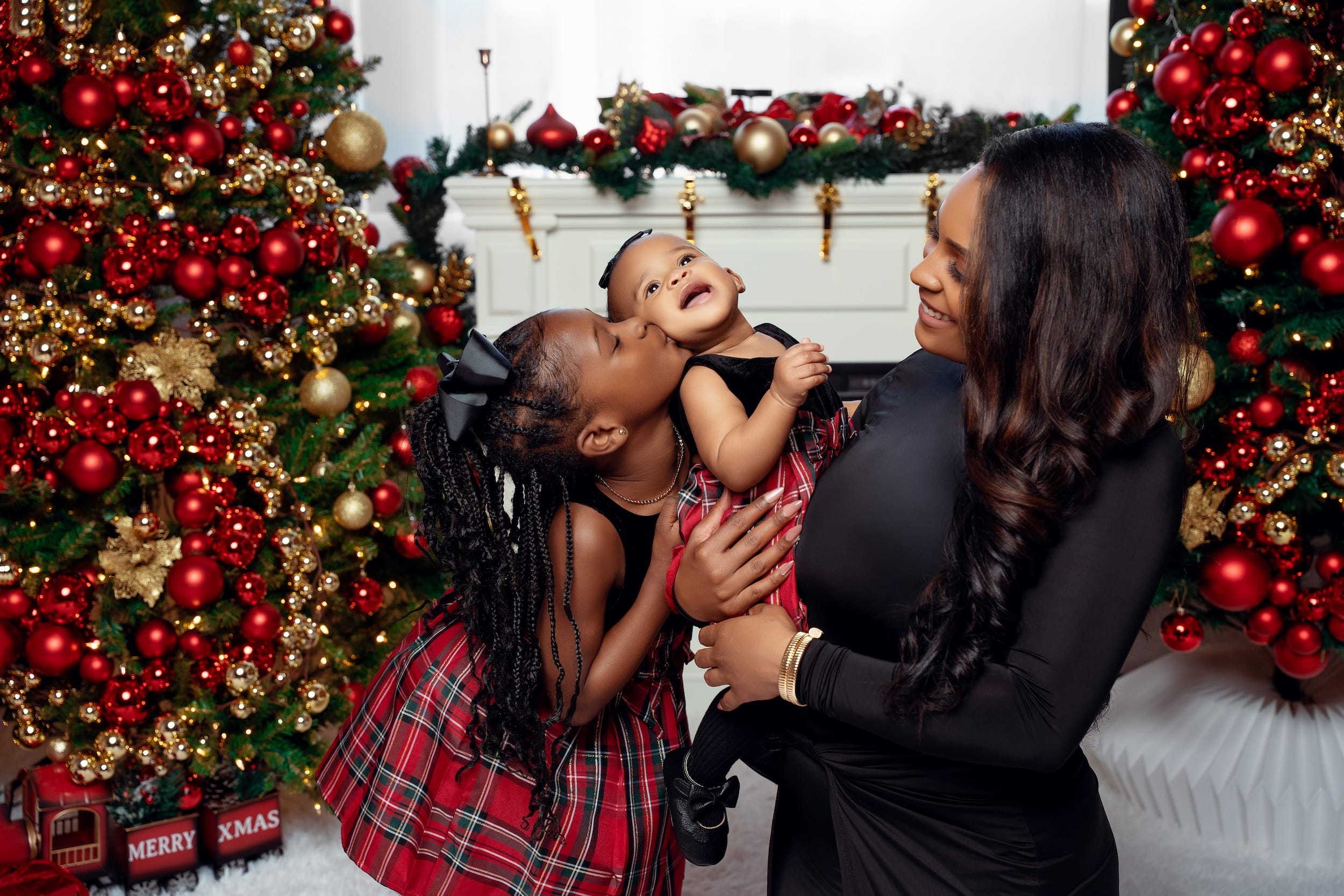 Mother and her two daughters sharing a kiss by the fireplace
